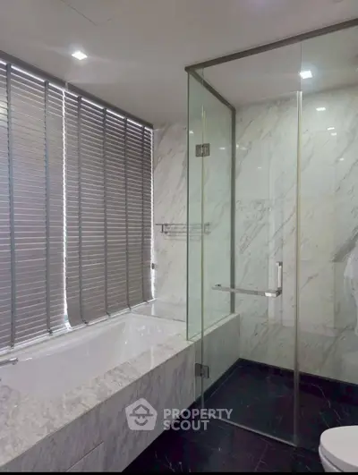 Luxurious bathroom with marble finishes and glass shower enclosure