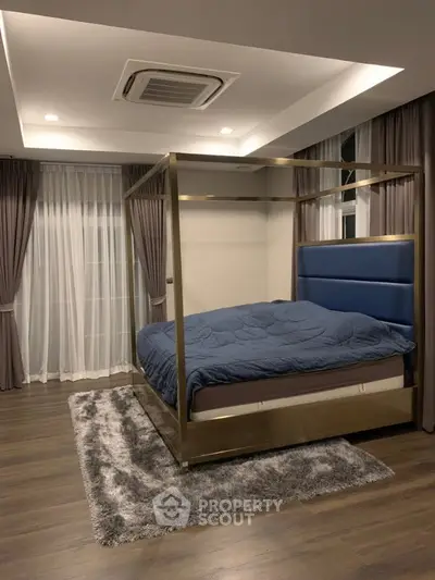Luxurious bedroom with modern canopy bed and elegant decor