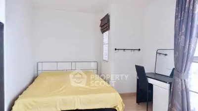Cozy bedroom with modern desk and large window for natural light.