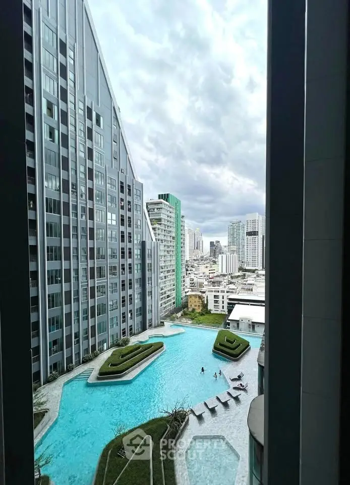 Stunning cityscape view from a modern high-rise building with a luxurious pool and landscaped garden.