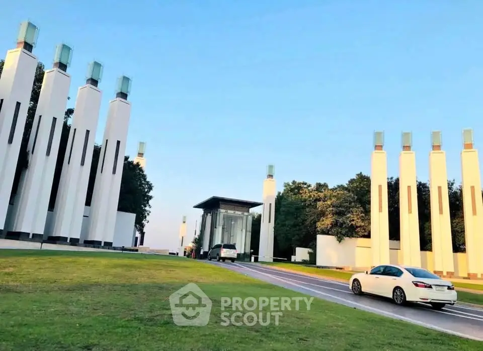 Modern architectural building with tall columns and lush greenery, perfect for luxury real estate development.