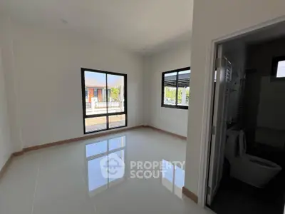 Spacious unfurnished room with large windows and glossy tiled floor