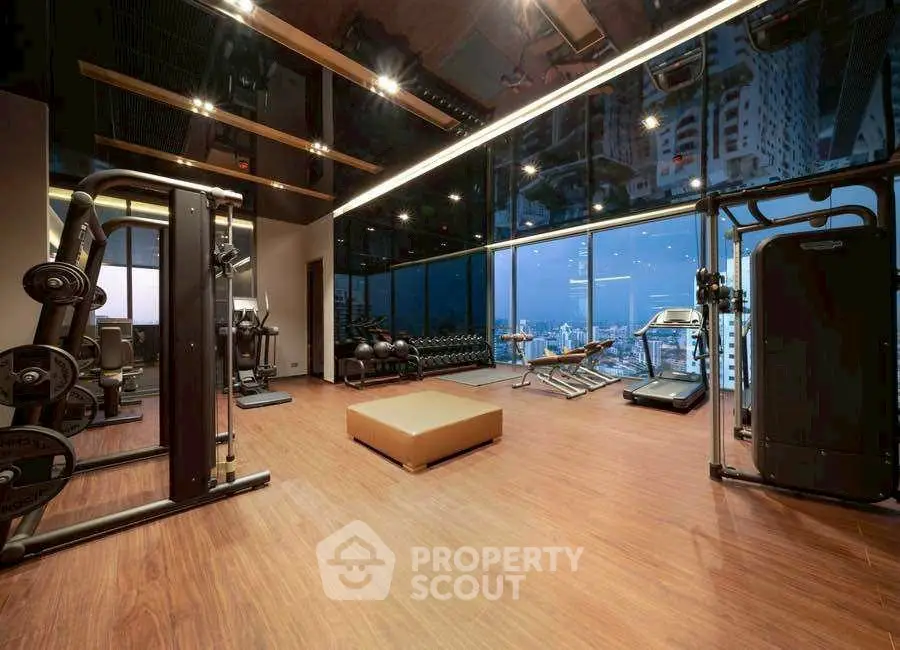 Luxurious high-rise gym with stunning city skyline view and modern fitness equipment.