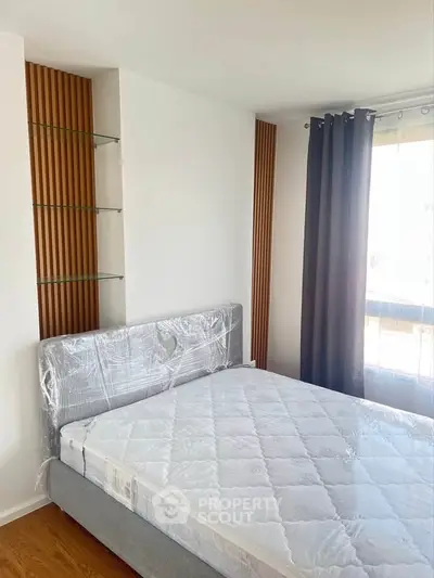 Modern bedroom with stylish wooden accents and large window for natural light.