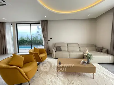 Modern living room with stylish furniture and pool view, featuring elegant lighting and cozy seating.