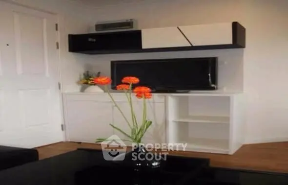 Modern living room with sleek TV unit and vibrant floral decor