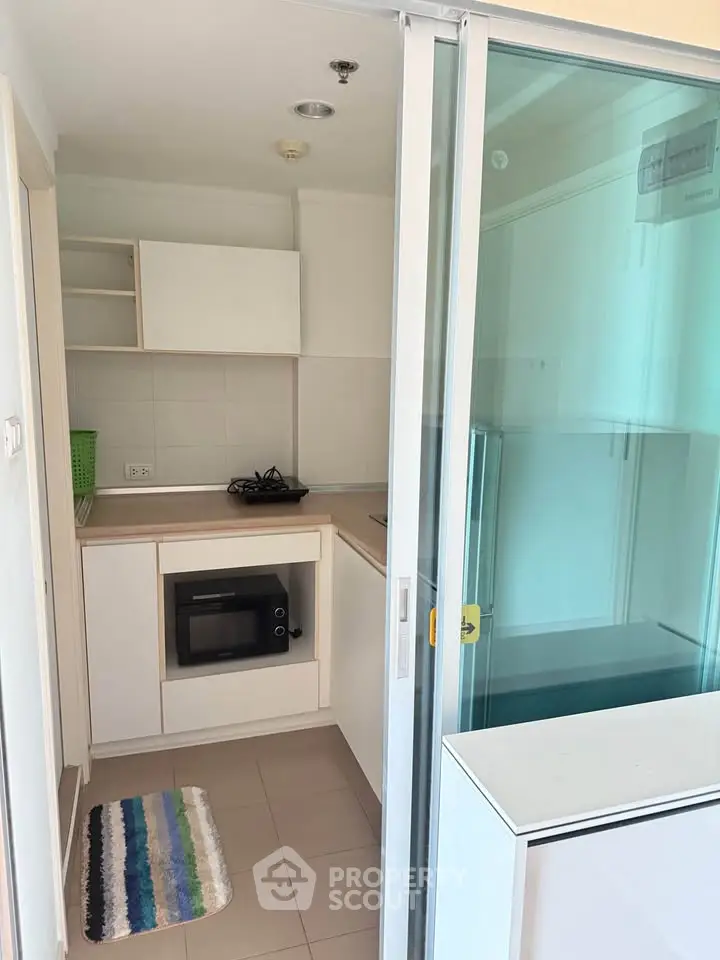 Compact modern kitchen with closed layout and gas stove, featuring sleek cabinetry and built-in appliances.