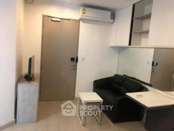 Cozy modern living room with sleek furniture and wall-mounted air conditioning unit.