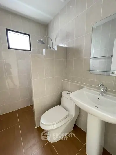 Modern bathroom with sleek fixtures and neutral tile design, perfect for a contemporary home.