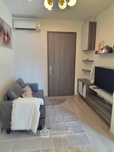 Cozy modern living room with stylish decor and air conditioning, perfect for relaxation.
