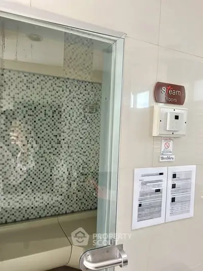 Luxurious steam room with modern glass door and stylish mosaic tiles, perfect for relaxation.