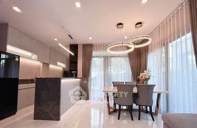 Luxurious modern kitchen with elegant dining area and stylish lighting fixtures.