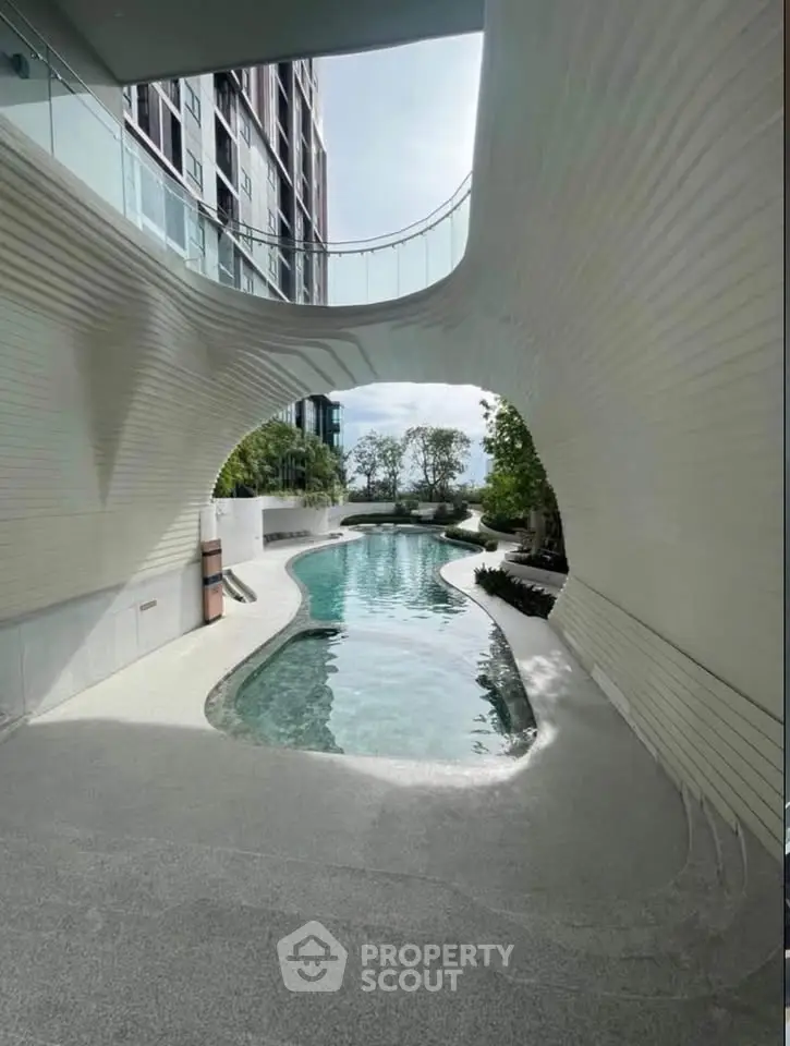 Luxurious modern apartment pool with unique architectural design and serene surroundings.