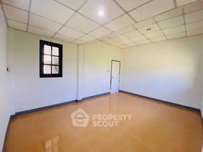 Spacious empty room with tiled floor and ceiling lights, perfect for customization.