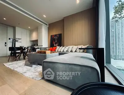 Modern living room with stylish decor and large windows offering city views.