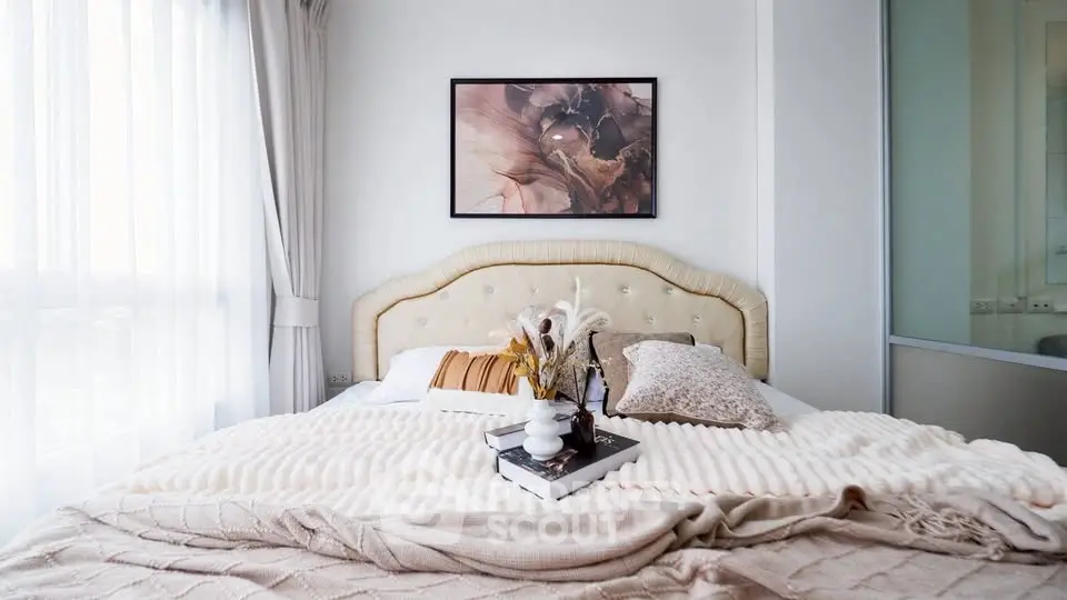 Luxurious bedroom with elegant decor and natural light, featuring a plush bed and stylish artwork.