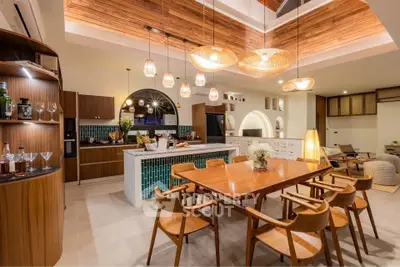 Stunning open-layout kitchen and dining area with modern wooden accents and elegant lighting.