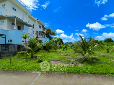 Spacious property with lush garden and modern building under clear blue sky.