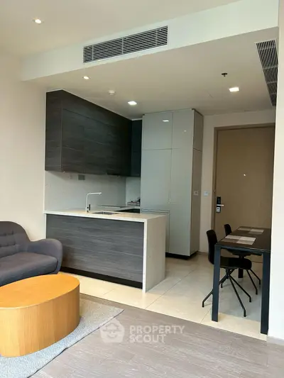 Modern open-layout kitchen with sleek cabinetry and cozy living area