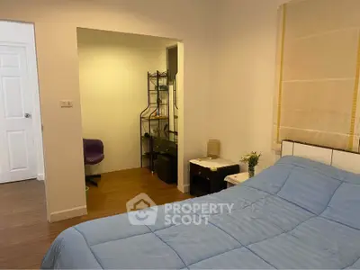 Cozy bedroom with blue bedding and adjacent study area, perfect for relaxation and productivity.