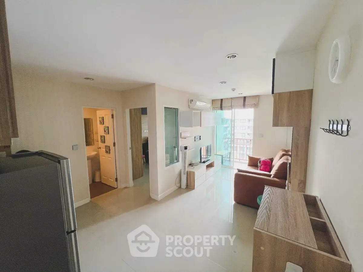 Modern living room with open layout and balcony view in a stylish apartment.