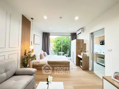 Modern studio apartment with open layout, featuring cozy bedroom, stylish living area, and compact kitchen.