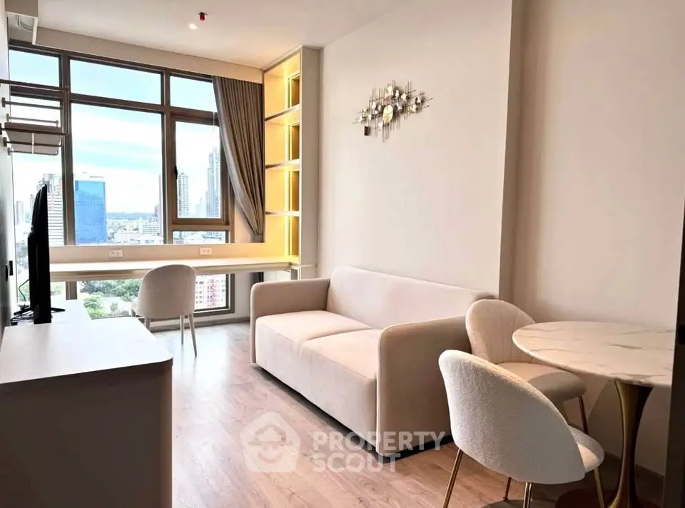 Modern living room with city view, featuring elegant furniture and large windows for natural light.