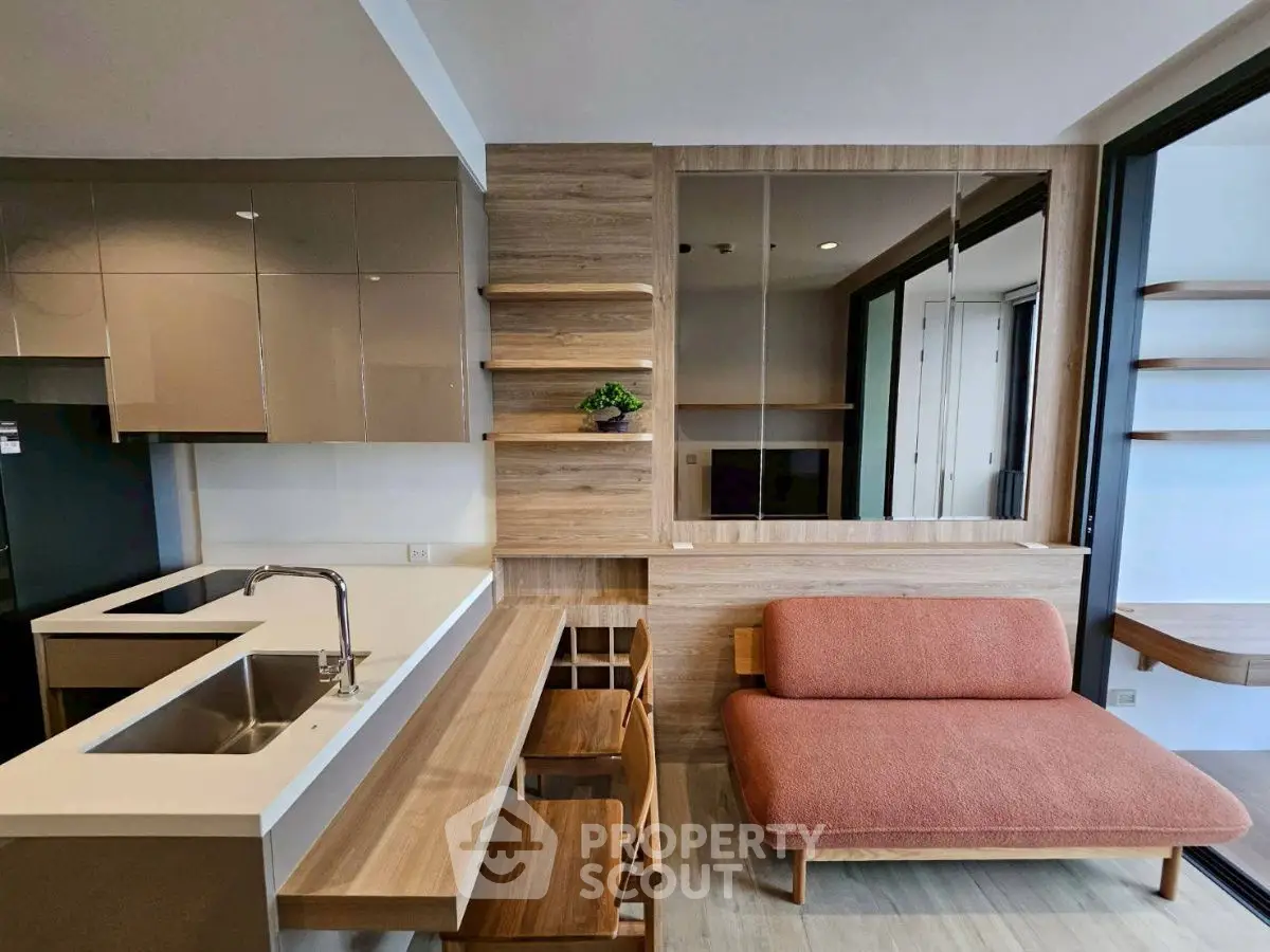 Modern open-plan kitchen and living area with sleek design and cozy seating.