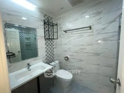 Modern bathroom with sleek fixtures and marble-style tiles