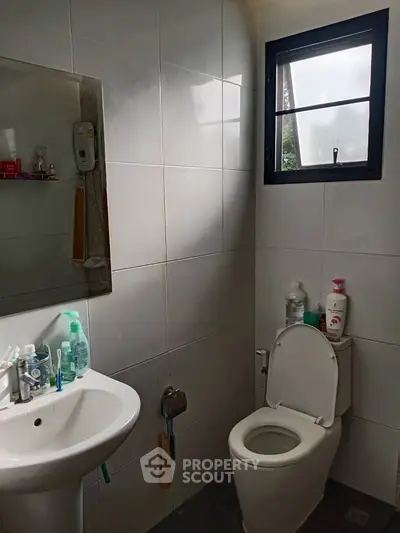 Modern bathroom with white tiles and natural light