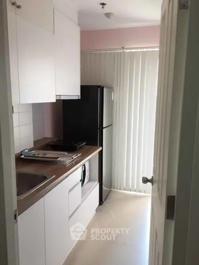 Compact kitchen with modern appliances and natural light