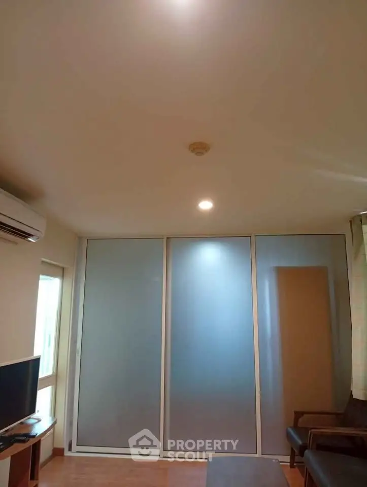 Modern living room with frosted glass sliding doors and air conditioning unit.