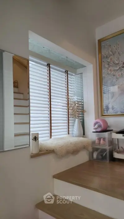Charming stairway nook with cozy decor and modern window blinds