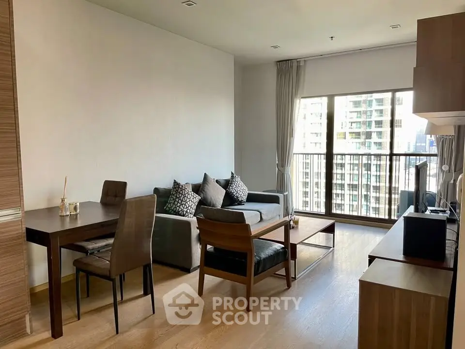 Modern living room with city view, stylish furniture, and natural light in a high-rise apartment.