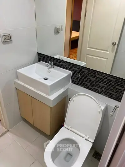 Modern bathroom with sleek sink and toilet in a stylish apartment.
