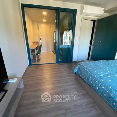 Modern bedroom with stylish decor and sliding glass doors leading to a cozy study area.