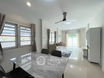 Spacious modern living room with dining area and large windows for natural light.