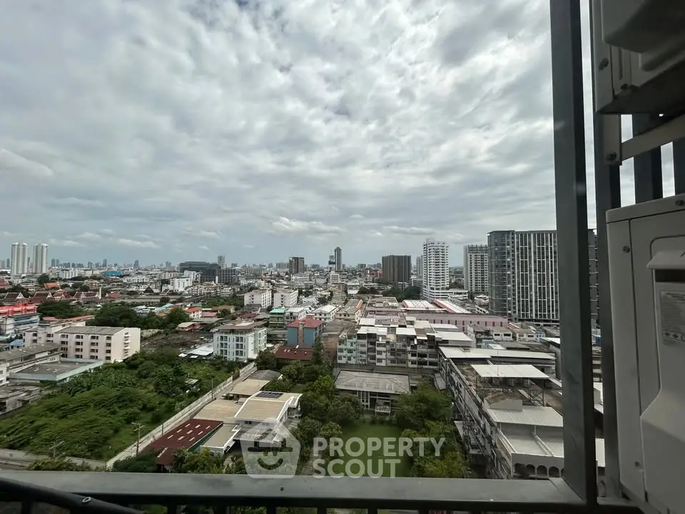 Stunning cityscape view from a high-rise balcony showcasing urban skyline and lush greenery.