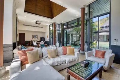 Luxurious open-plan living room with high ceilings and pool view, perfect for entertaining.