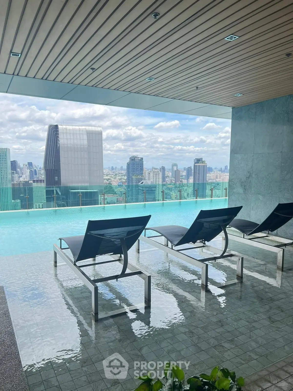 Luxurious rooftop pool with stunning city skyline view and modern lounge chairs.