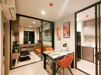 Modern open-plan living and dining area with stylish decor and glass partitions.