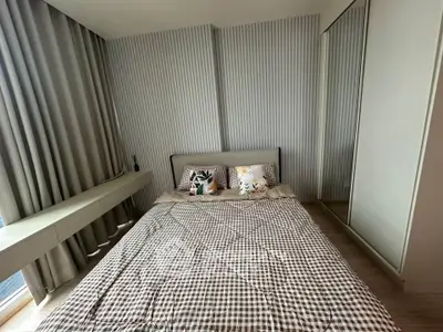 Modern bedroom with stylish decor and large window for natural light.