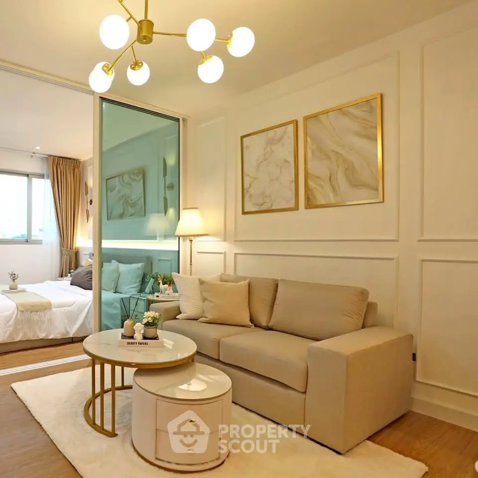 Elegant living room with modern decor and cozy seating adjacent to a stylish bedroom.