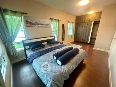 Spacious bedroom with elegant decor and large windows for natural light