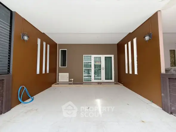 Spacious covered patio with modern lighting and double doors