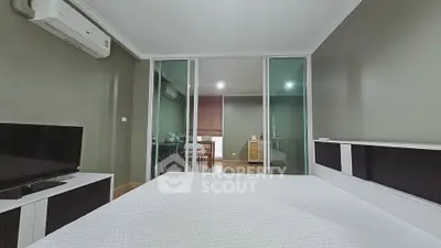 Spacious bedroom with modern decor and sliding glass doors leading to a study area.