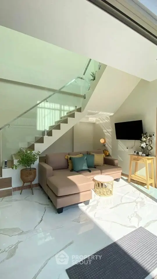 Modern living room with sleek staircase and cozy seating area