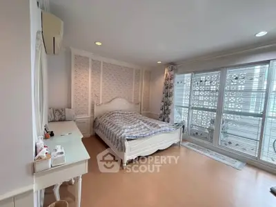 Spacious bedroom with elegant decor and large windows for natural light