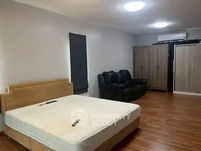 Spacious bedroom with modern furnishings and wooden flooring