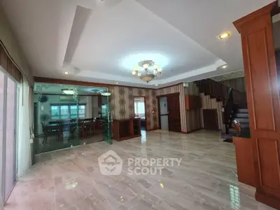 Spacious open-plan living room with elegant lighting and polished floors in a modern home.
